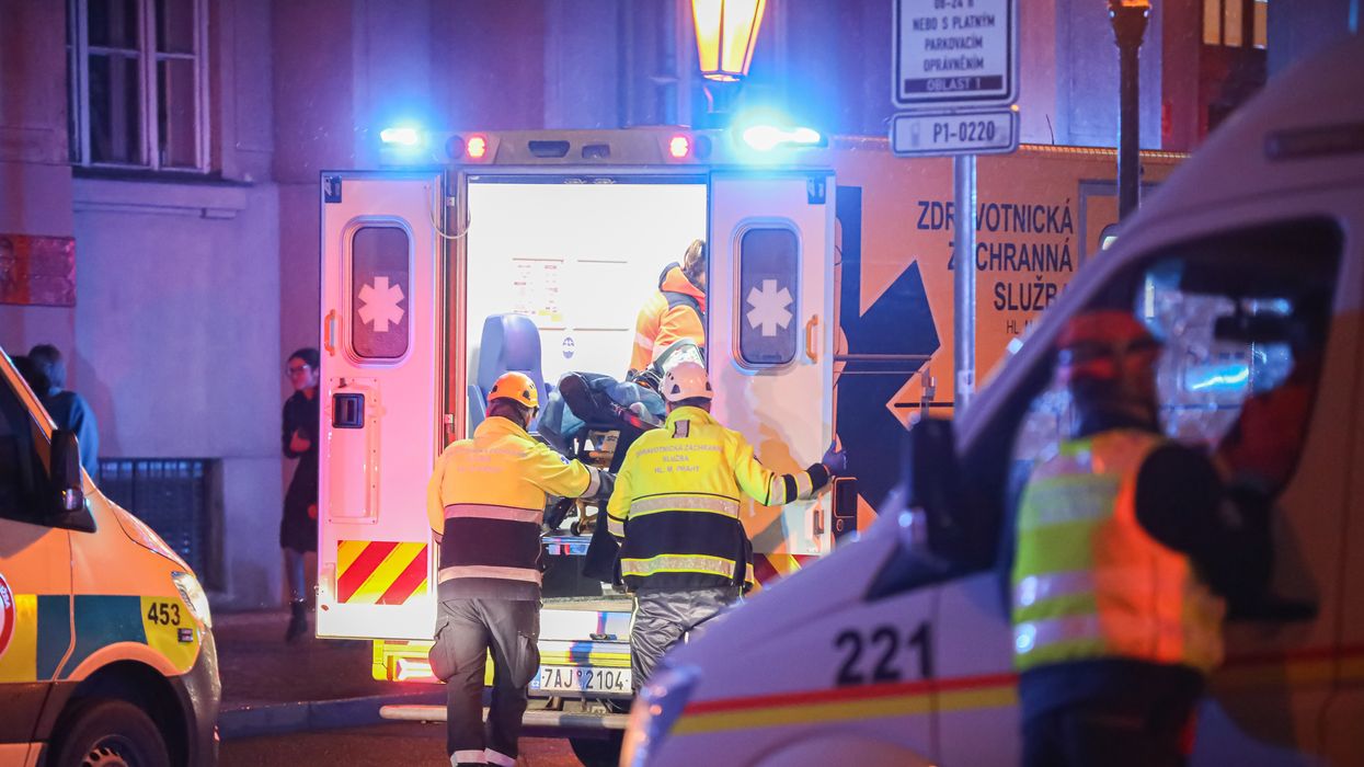 Paramedics load a stretcher into an ambulance