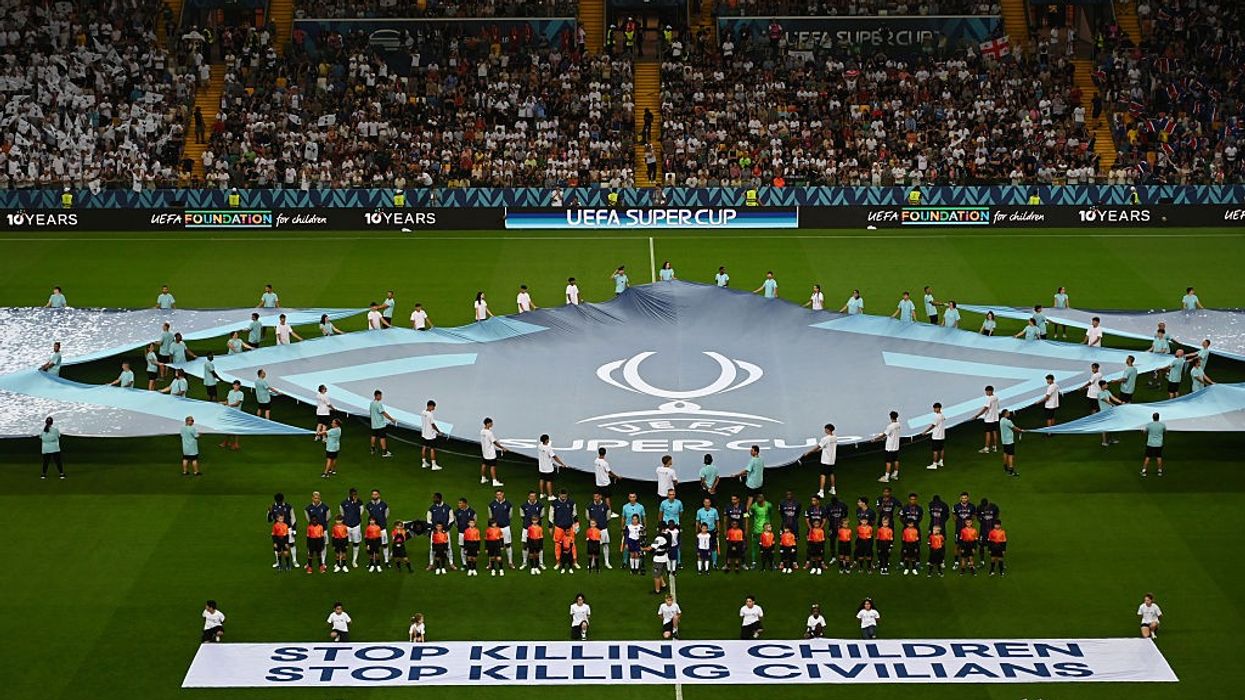 Paris Saint-Germain v Tottenham Hotspur - UEFA Super Cup 2025; banner says "stop killing children, stop killing civilians"