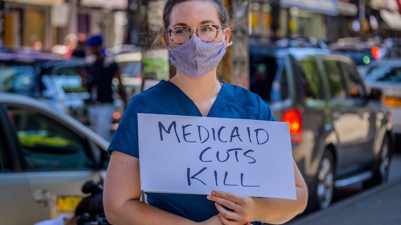 Participant holding a Medicaid Cuts Kill sign at the rally.