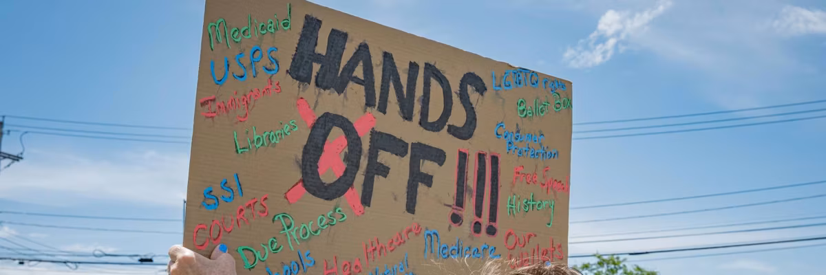 Participant seen holding a sign at the protest. A large