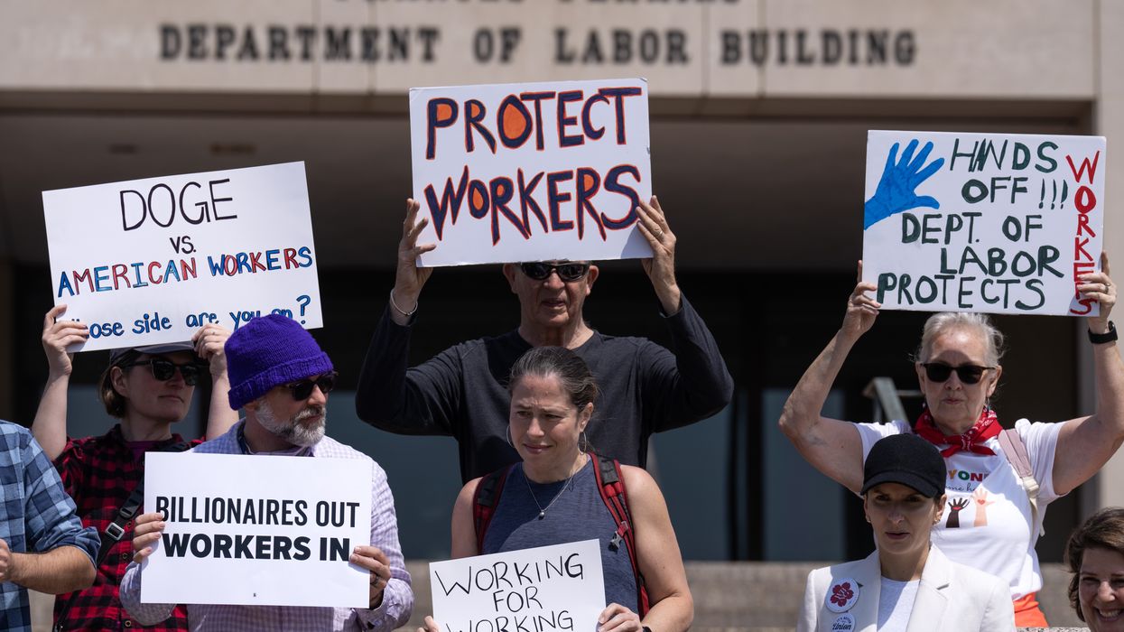 Participants hold signs during a news conference with Federal Workers Against DOGE