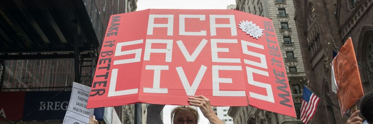 Participants hold signs supporting the ACA.