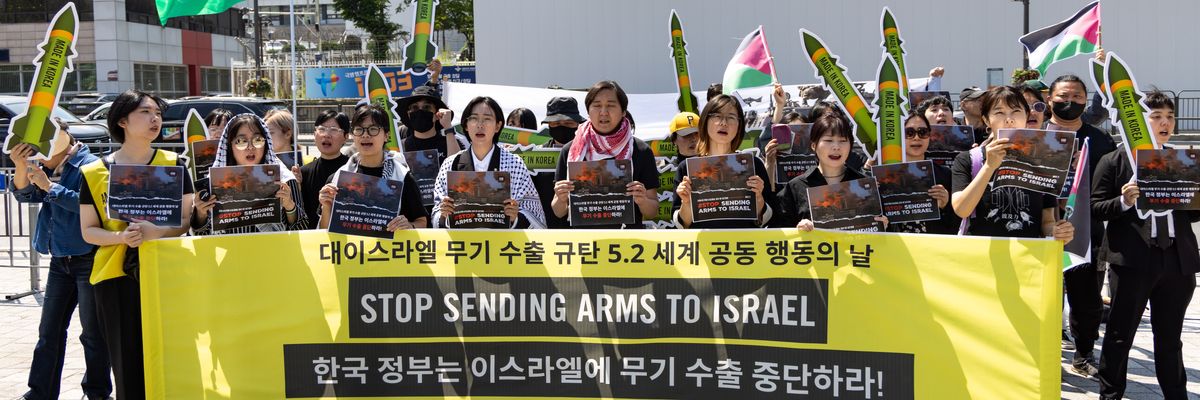 Participants hold signs that read, "Korean Government: Stop Arms Exports to Israel"