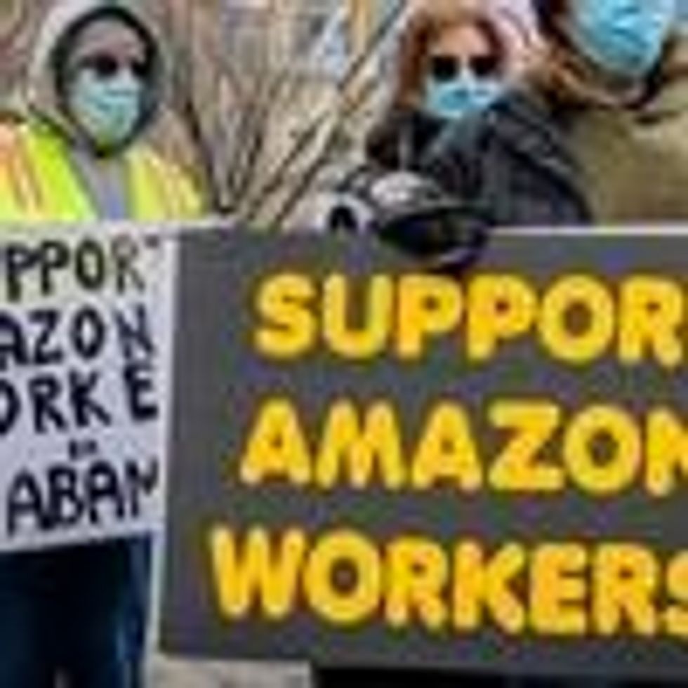 Participants seen holding signs and marching on a picket line during a solidarity event in Manhattan showing support for Amazon workers in Bessemer, Alabama.
