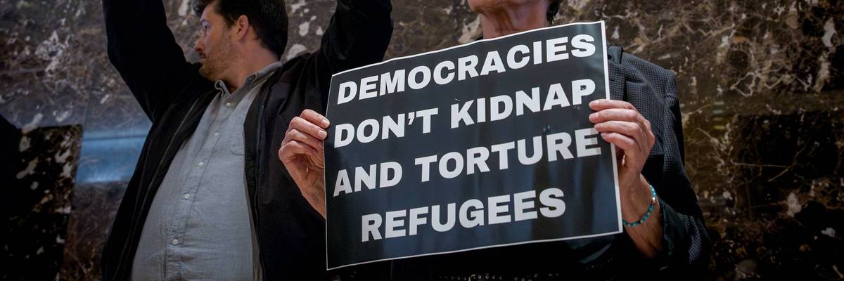 Participants seen holding signs at the protest. Around 30...