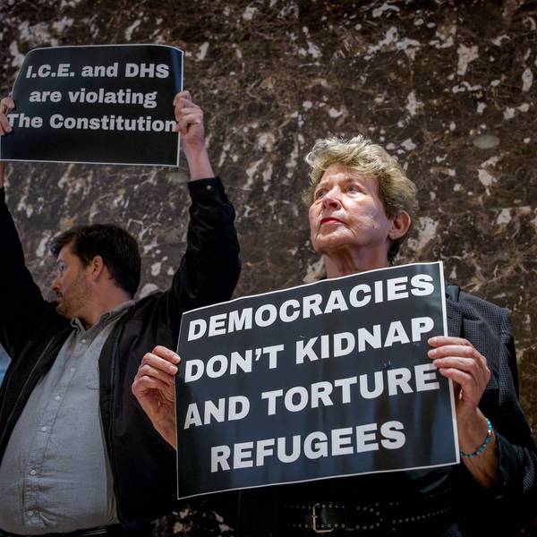 Participants seen holding signs at the protest. Around 30...