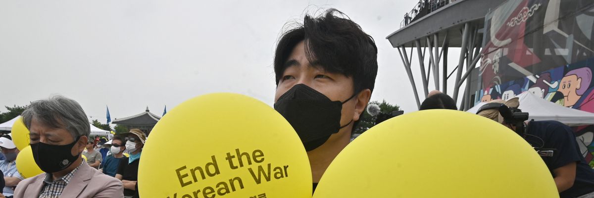 Participants wave yellow balloons reading "End the Korean War" during a peace festival