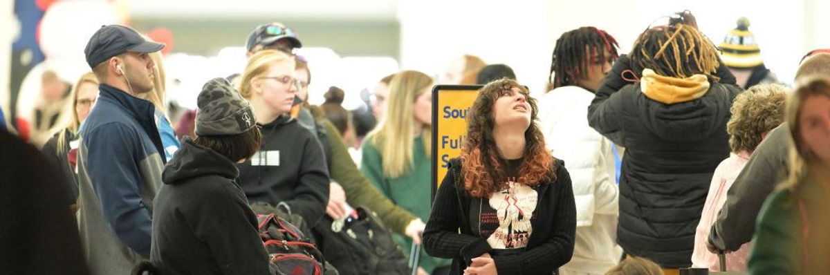 Passengers wait in line to book flights at a Southwest Airlines ticket counter at Denver International Airport