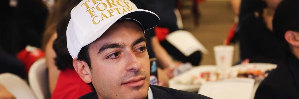 Paul Ingrassia wears a white baseball cap emblazoned with "Trump Force Captain" in gold lettering