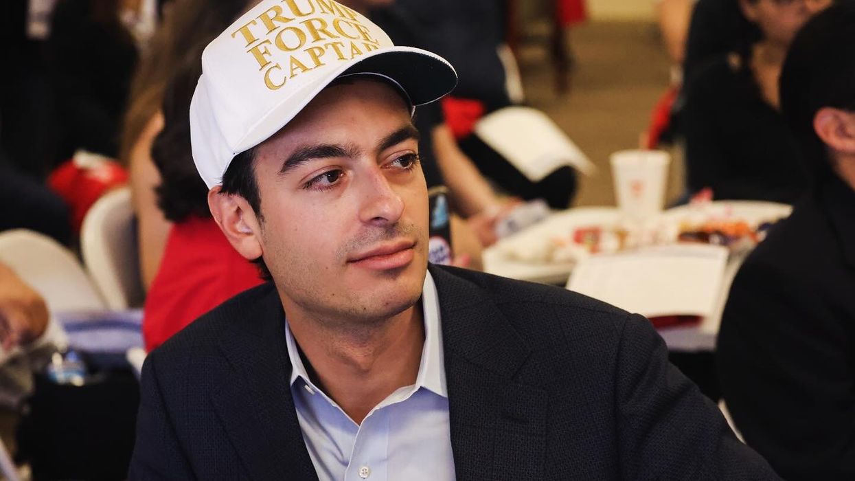 Paul Ingrassia wears a white baseball cap emblazoned with "Trump Force Captain" in gold lettering