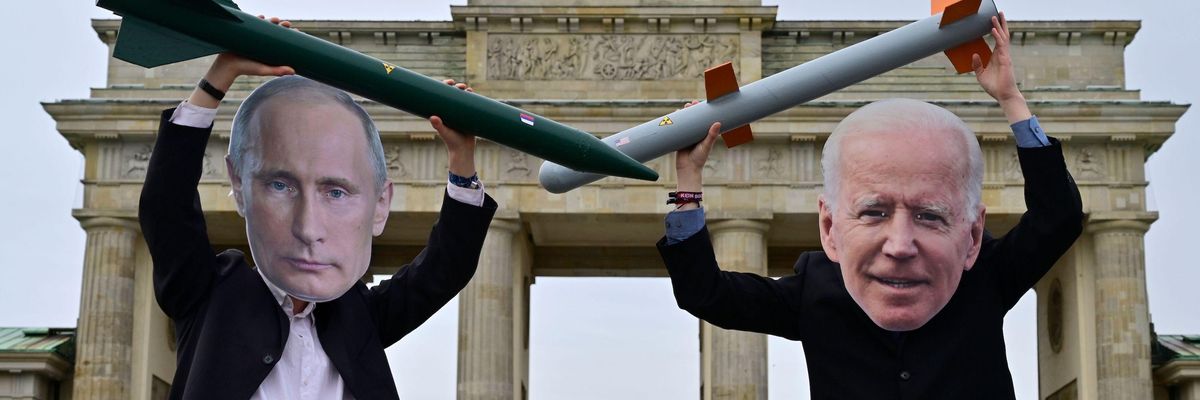Peace activists wearing masks of Russian President Vladimir Putin (L) and U.S. President Joe Biden pose with mock nuclear missiles in front of Berlin's landmark Brandenburg Gate on January 29, 2021 in an action to call for more progress in nuclear disarmament. (Photo: John Macdougall/AFP via Getty Images)