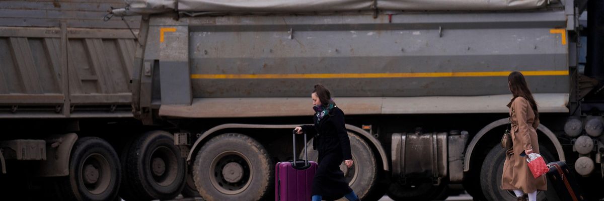 Pedestrians walk past a new road barricade set up in the divided town of Mitrovica, Kosovo on December 28, 2022.