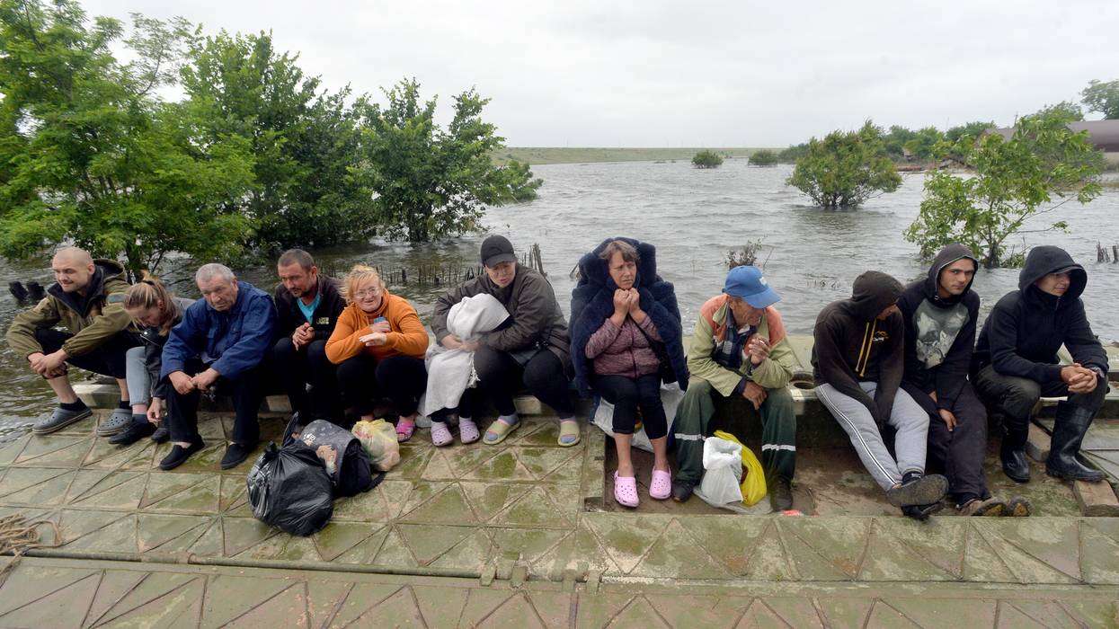 People are pictured in Afanasiyivka, Mykolaiv region on June 12, 2023 after the Kakhovka dam collapse.