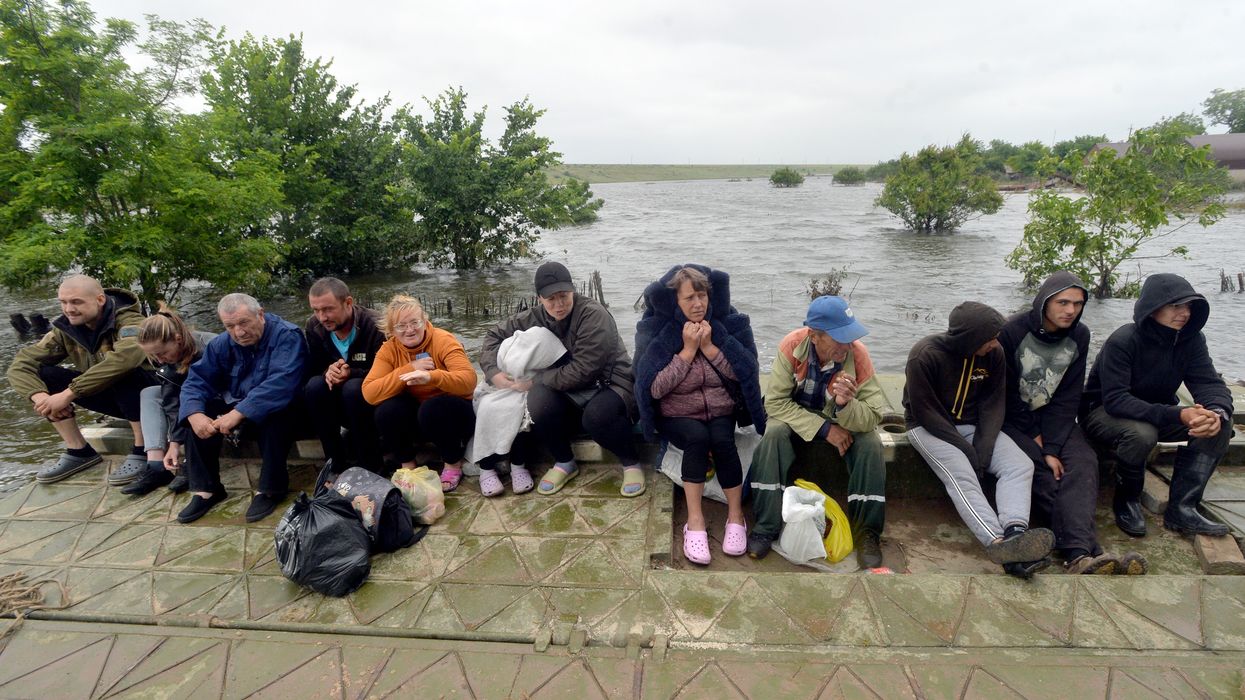 People are pictured in Afanasiyivka, Mykolaiv region on June 12, 2023 after the Kakhovka dam collapse.