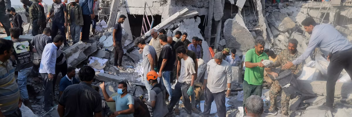 People are seen amid the rubble of a bombed girls' school in Minab, Iran
