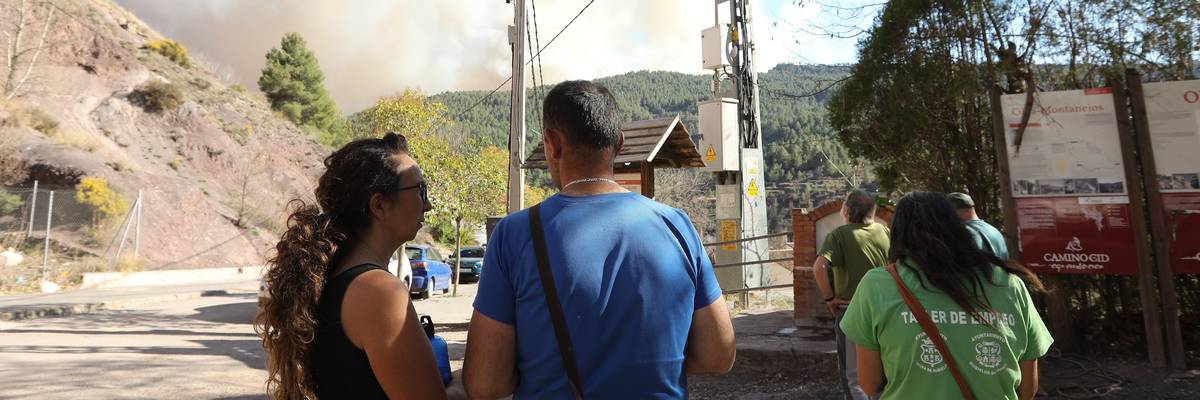 People at risk from a wildfire that broke out in Villanueva de Viver, Spain watch in the nearby village of San Agustín on March 23, 2023.