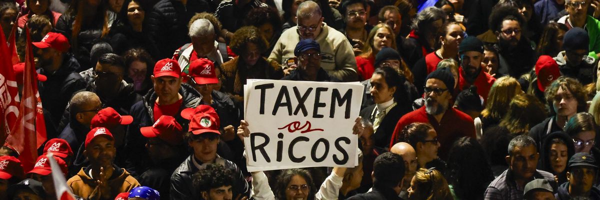 People attend a demonstration in support of taxing the super-rich