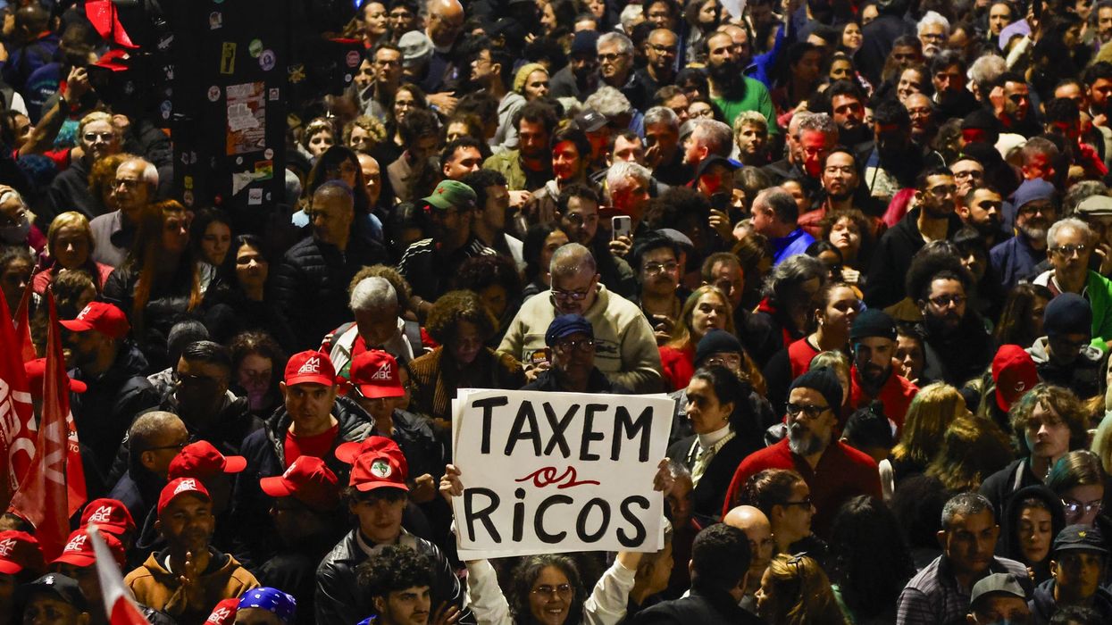 People attend a demonstration in support of taxing the super-rich