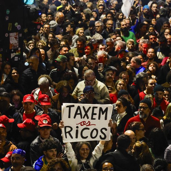 People attend a demonstration in support of taxing the super-rich