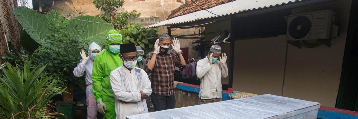 People attend a funeral of a coronavirus victim in Indonesia