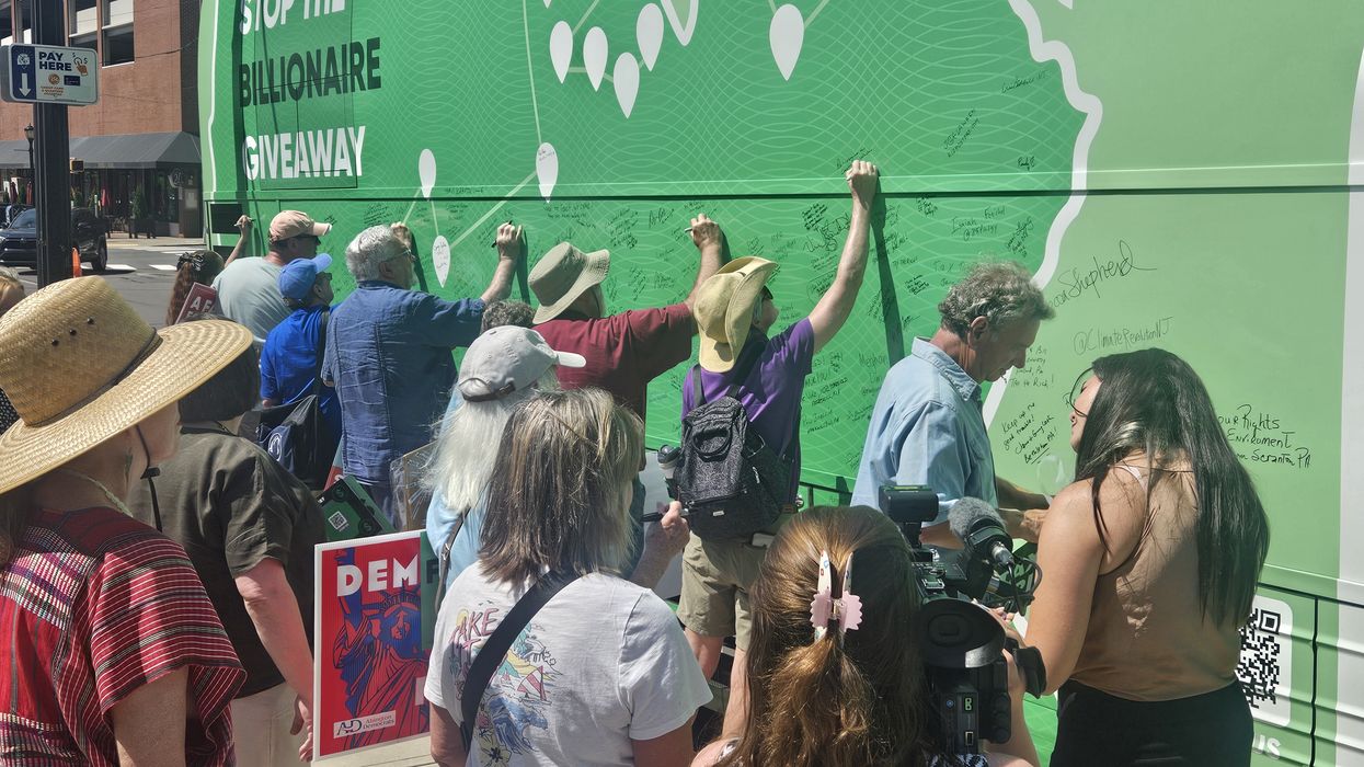 People attend the “Stop the Billionaire Tax Giveaway" bus tour.