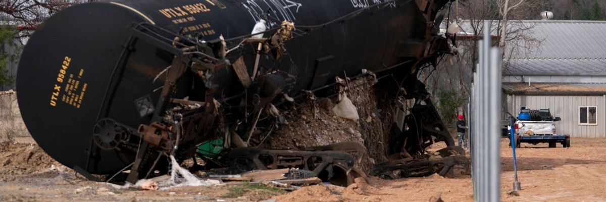 People build a fence near the Swannanoa River in a landscape scarred by Hurricane Helene
