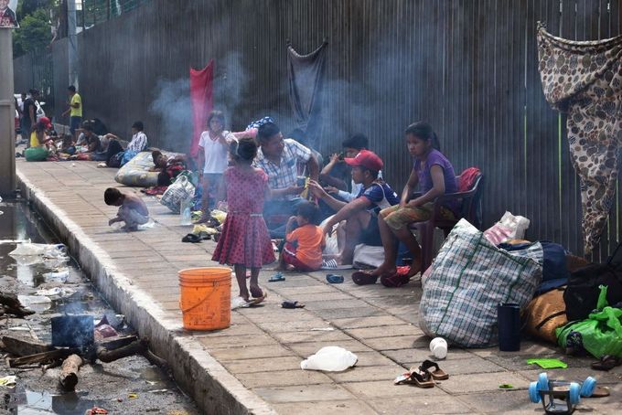 People camp on a sidewalk.