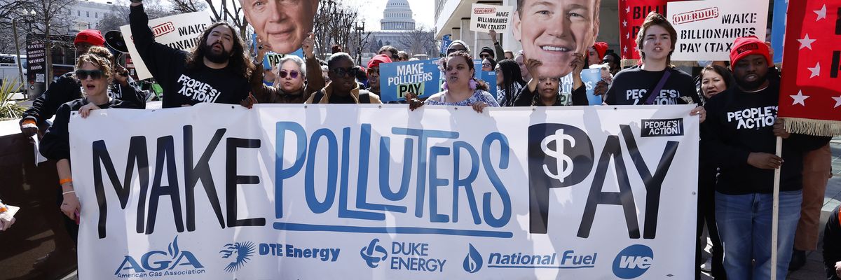 people carry a banner reading, Make Polluters Pay