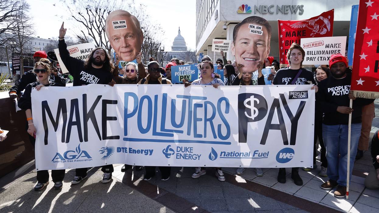 people carry a banner reading, Make Polluters Pay