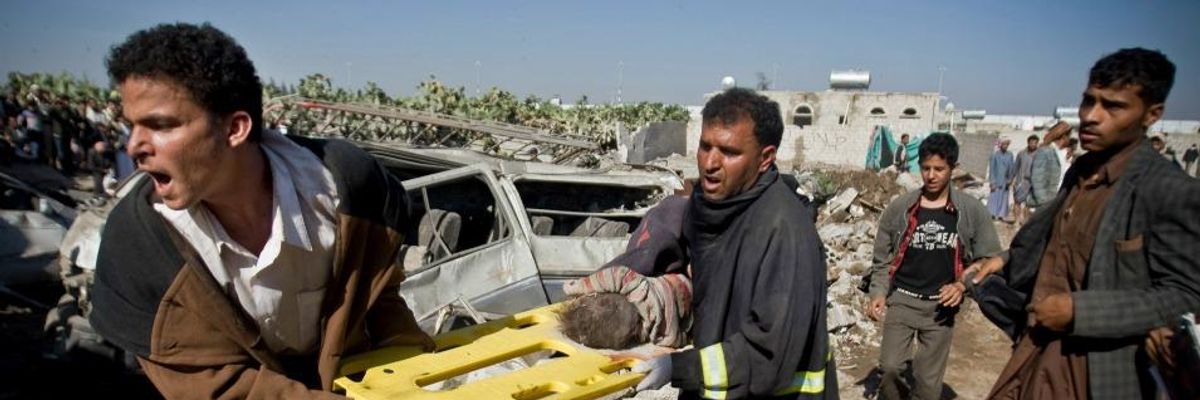 People carry the body of a child they uncovered from under the rubble of houses destroyed by Saudi airstrikes near Sanaa Airport, Yemen, Thursday, March 26, 2015