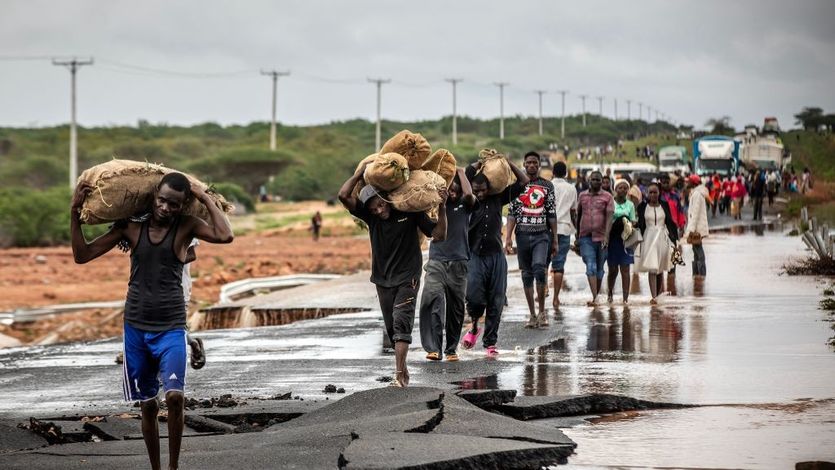 People carry their belongings in Kenya after floods