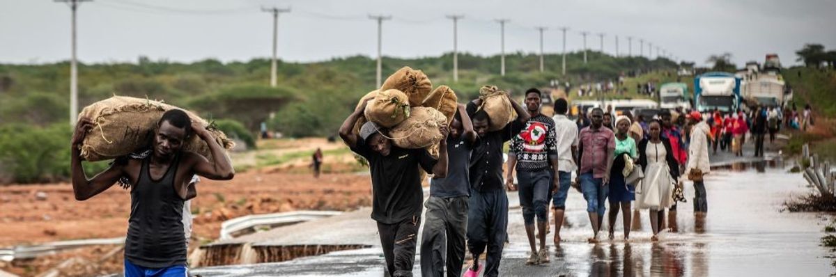 People carry their belongings in Kenya after floods