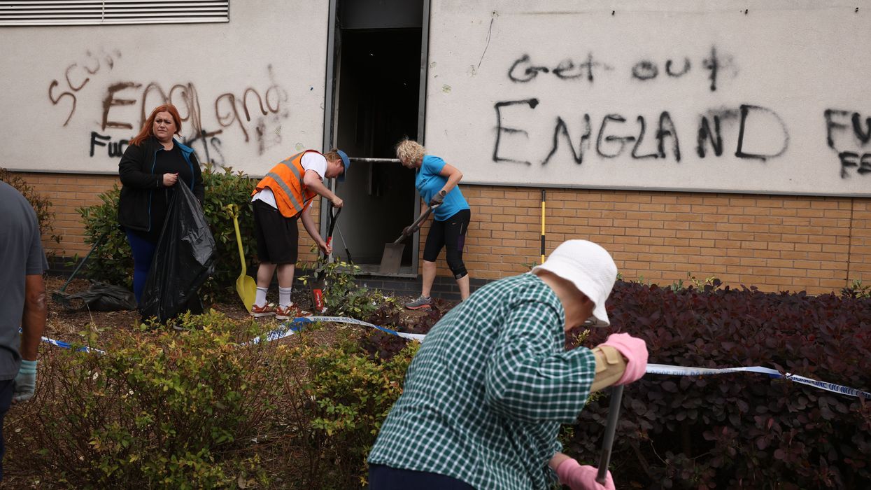 People clean up debris outside a Holiday Inn Express