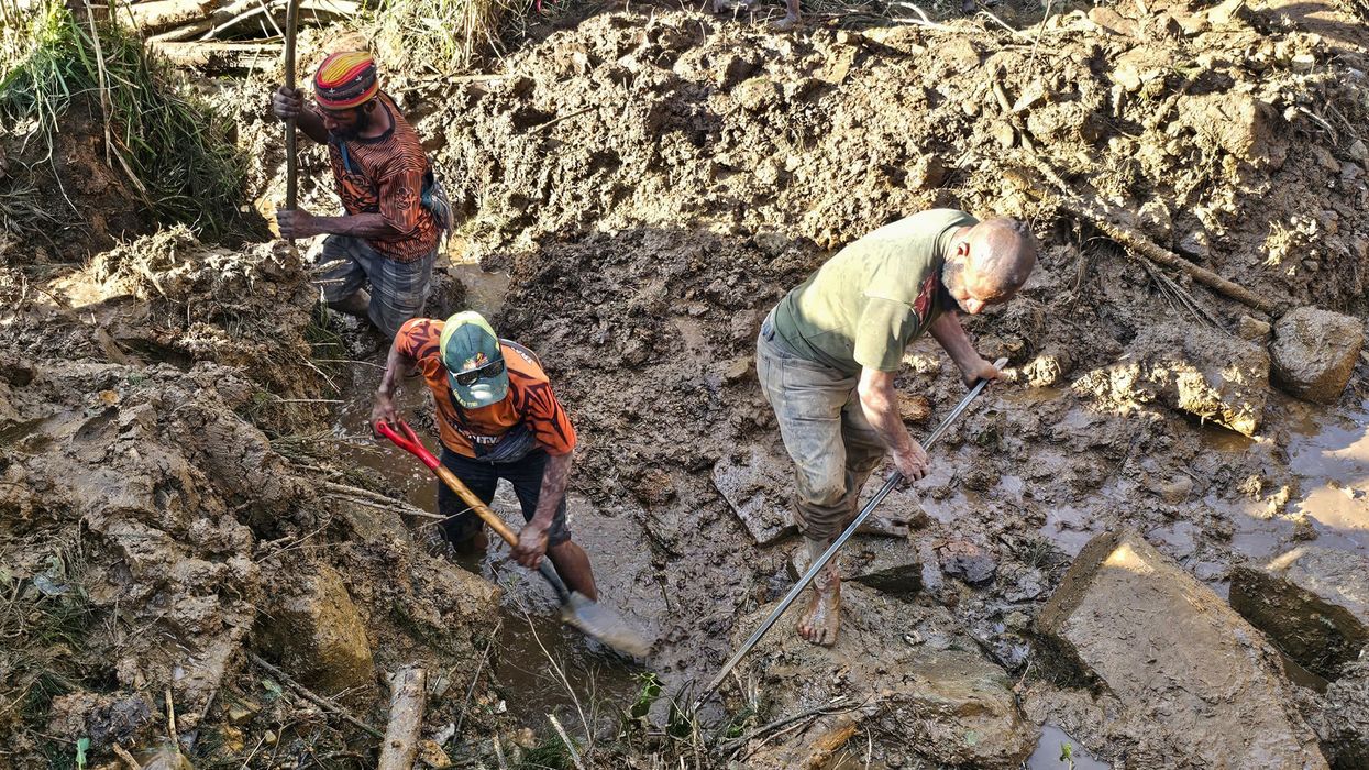 People dig through rubble of PNG landslide.