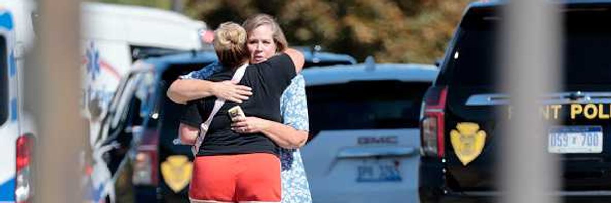 People embrace near the scene of a shooting at a church in Grand Blanc, Michigan