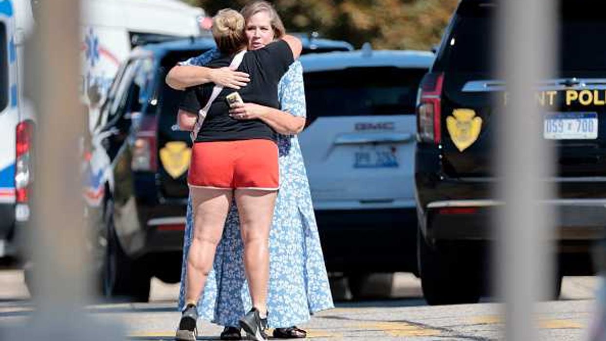 People embrace near the scene of a shooting at a church in Grand Blanc, Michigan
