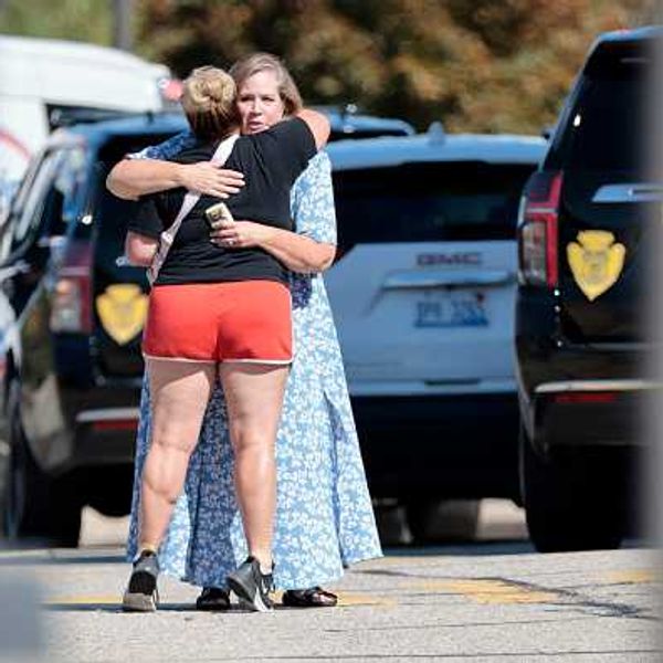 People embrace near the scene of a shooting at a church in Grand Blanc, Michigan