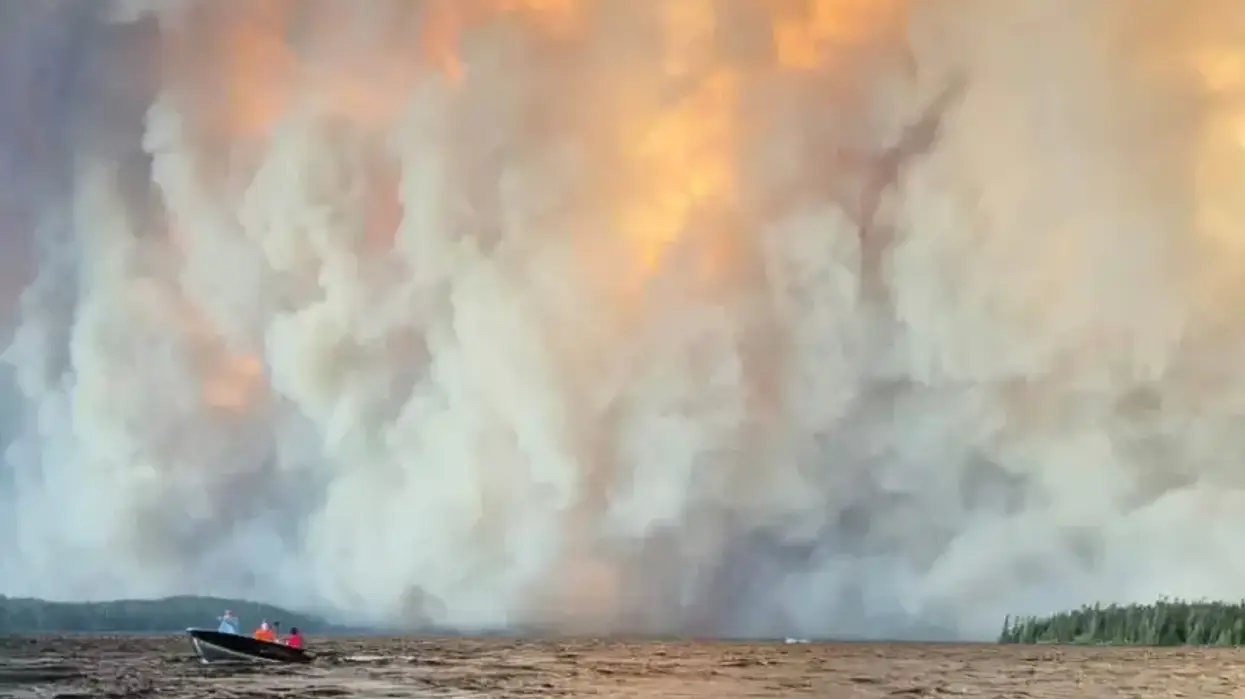 People flee wildfires in motor boat.