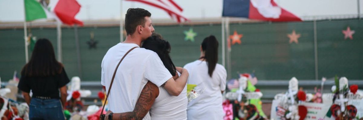 People gather at a makeshift memorial honoring mass shooting victims