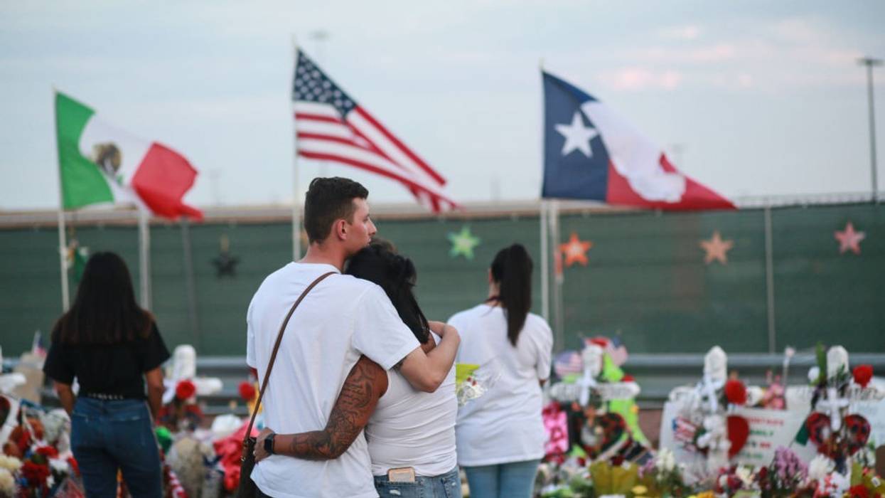 People gather at a makeshift memorial honoring mass shooting victims
