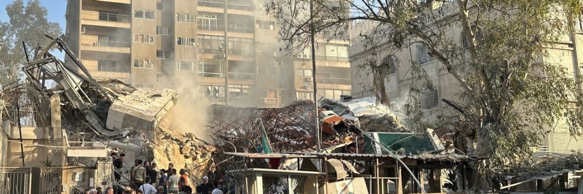 People gather at the site of the bombed Iranian consulate in Damascus