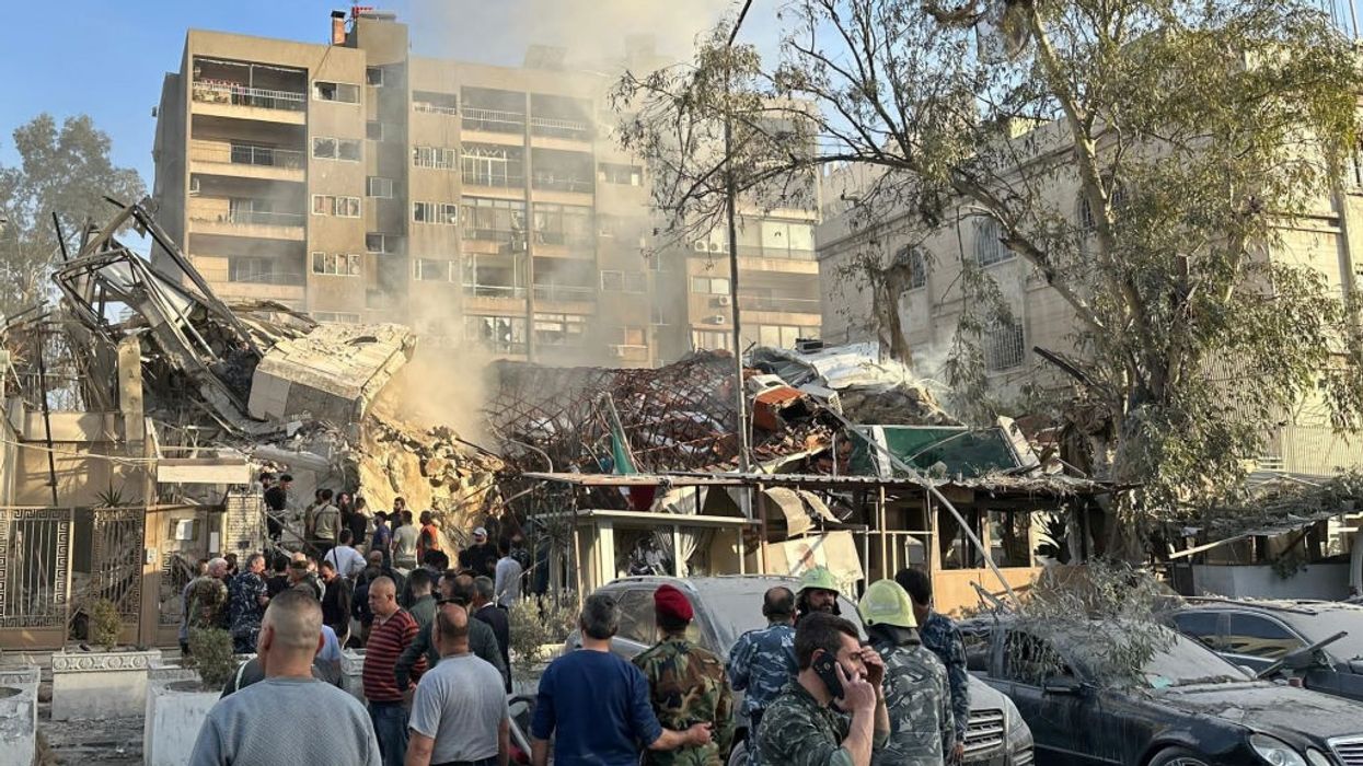 People gather at the site of the bombed Iranian consulate in Damascus