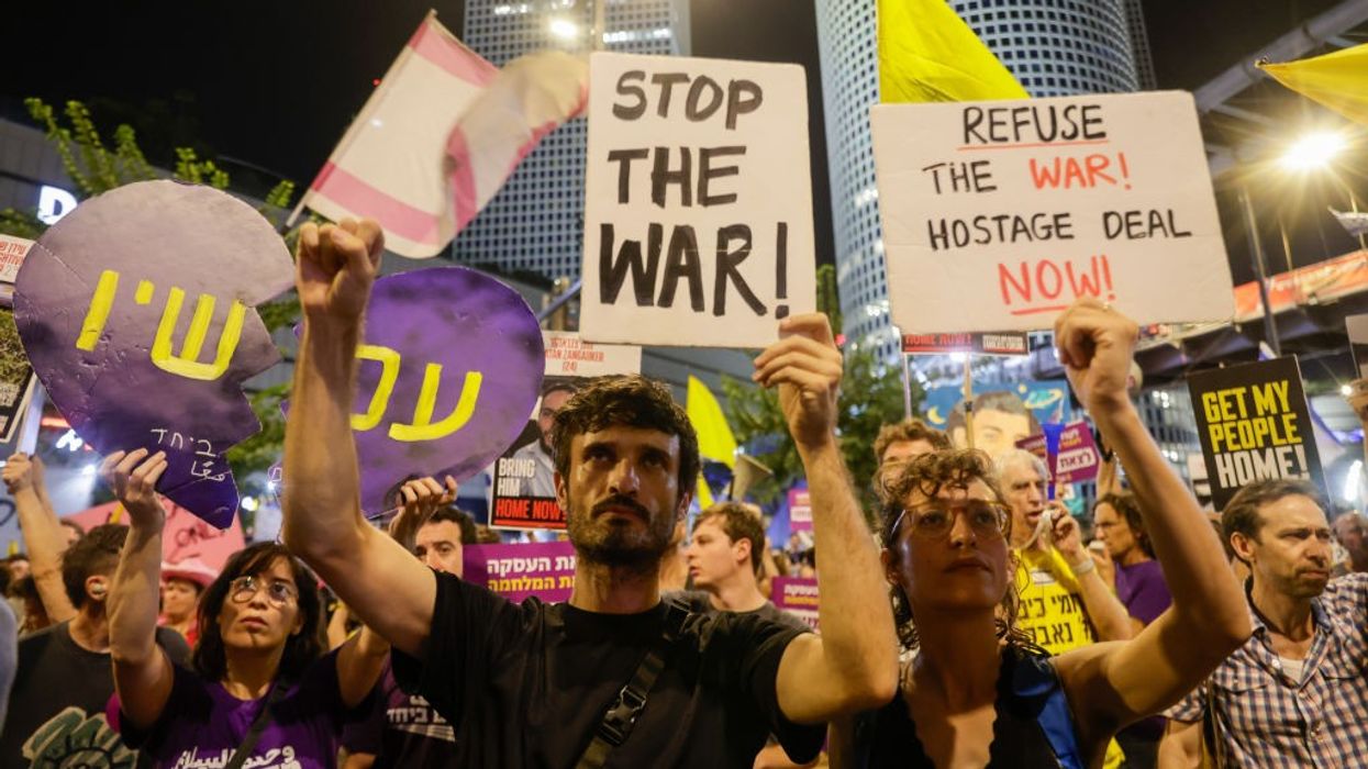 People gather with banners and flags to protest against Israeli Prime Minister Benjamin Netanyahu