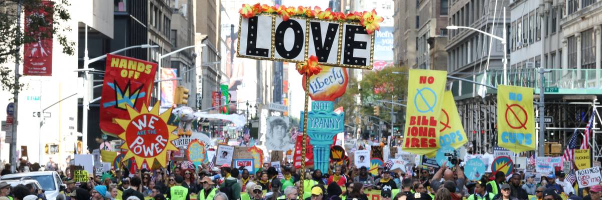 People hold a sign reading, "Love" at No Kings Day in New York City.