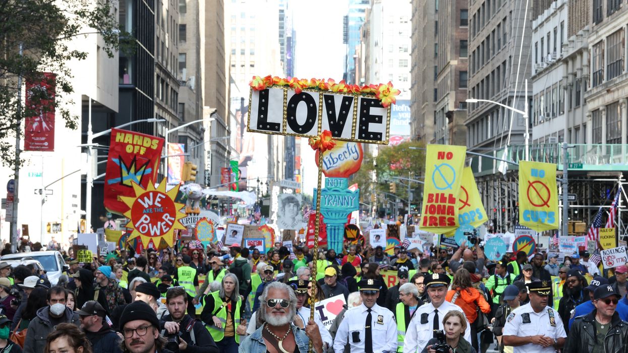 People hold a sign reading, "Love" at No Kings Day in New York City.
