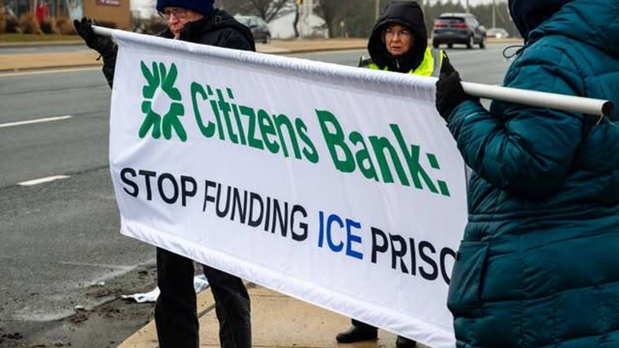 People hold banner calling on Citizens Bank to stop funding ICE prisons.