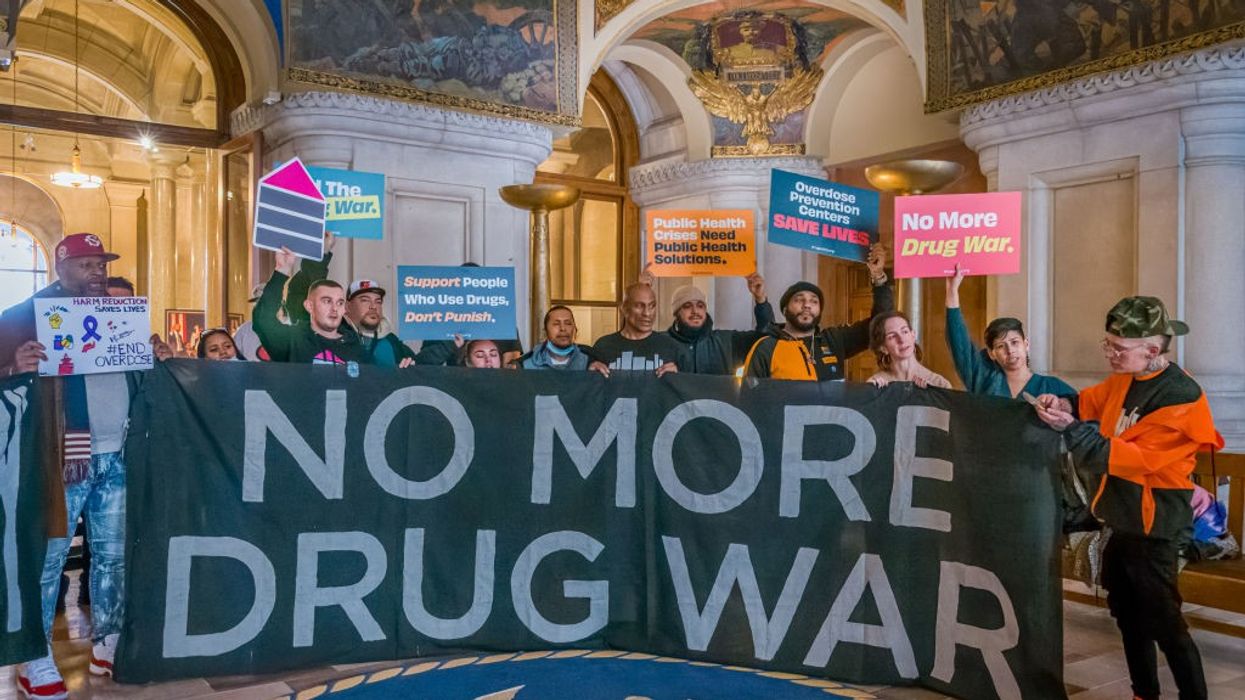 People hold banner that says "No More Drug War"