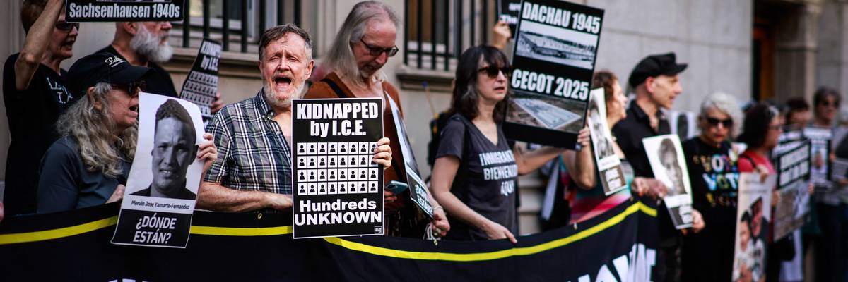 People hold signs and read the names of detainees at CECOT