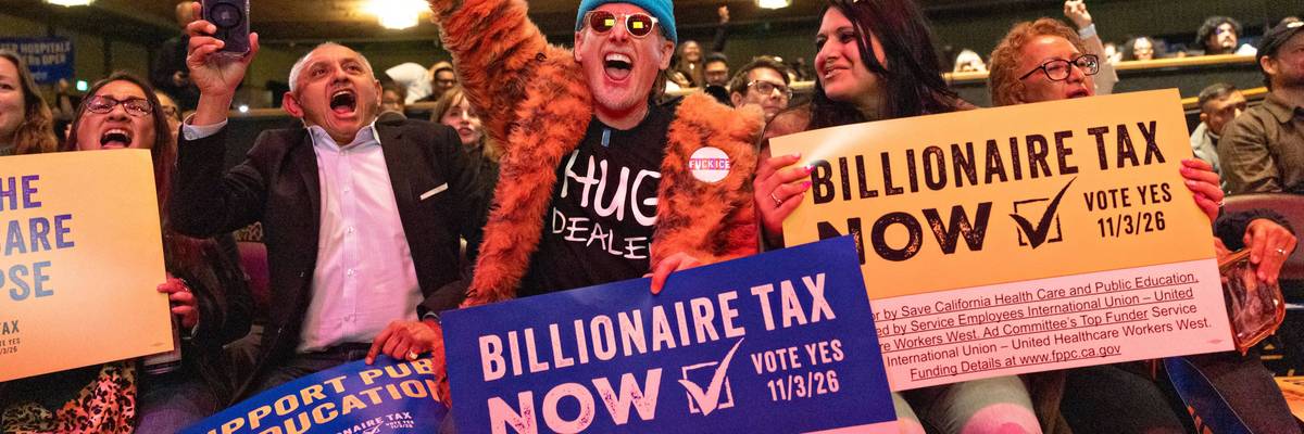People hold signs reading, "Billionaire Tax Now" during a rally in Los Angeles