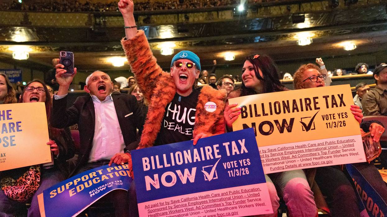 People hold signs reading, "Billionaire Tax Now" during a rally in Los Angeles